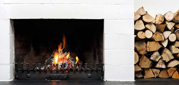 Glowing Embers Ltd. white fireplace with logs